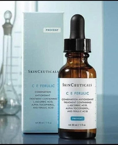 SkinCeuticals C E Ferulic skincare serum and packaging on a reflective surface.